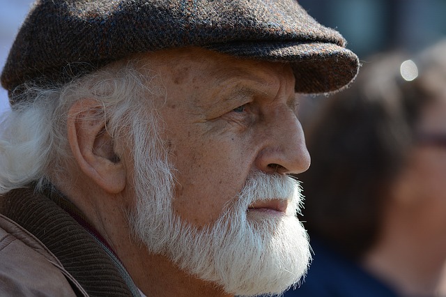 An old man with cap staring somewhere