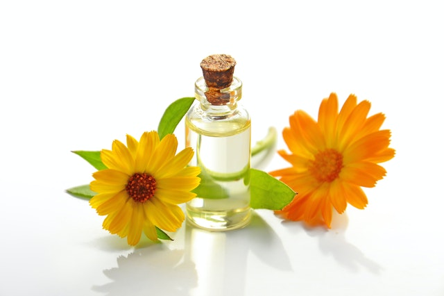 A bottle of baby oil for beard with lead surrounded by two yellow flower